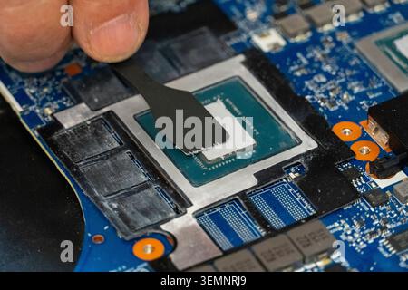 Close-up of thermal paste being applied to computer CPU with spatula tool, symbolizing repair, maintenance and cooling optimization in modern electron Stock Photo