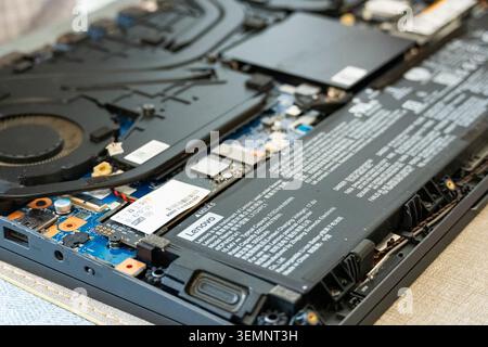 Editorial photo of an opened Lenovo laptop showing SSD storage, battery and cooling system during maintenance, repair or hardware upgrade. Tashkent, U Stock Photo