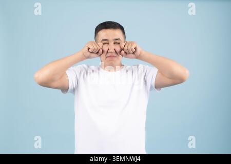 Young man pointing fingers at his eyes asking to look closely Stock Photo