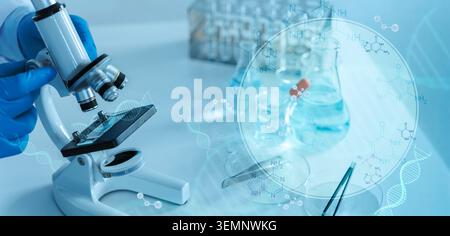 Close-up of a gloved hand using a microscope beside lab glassware, enhanced with DNA and molecular graphics to represent biomedical research, diagnost Stock Photo