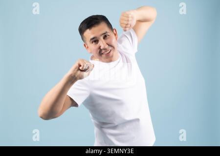 Energetic young man celebrating success shouting with joy in studio Stock Photo