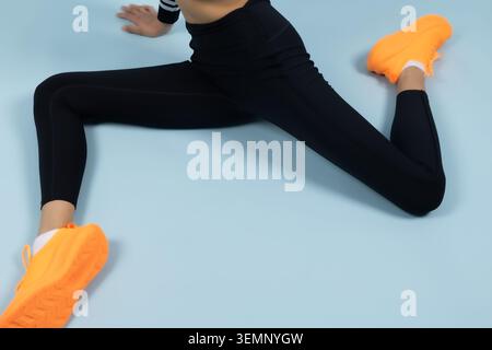 Playful fitness woman lying on floor with her legs raised up Stock Photo
