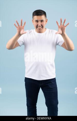 Shocked young man raising his hands up in fear looking scared Stock Photo