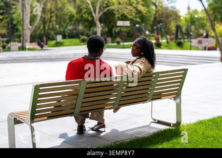 Thoughtful african american man and woman friends spending weekend outdoors together in park. Stock Photo