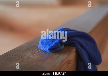 Blue Microfiber Cleaning Cloth Resting On Wooden Railing During House Cleaning Stock Photo