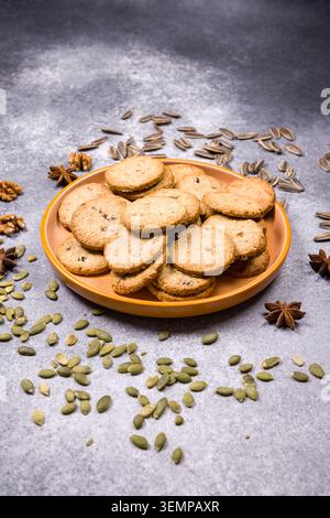 Walnuts scattered on a rustic orange tablecloth on a dark background ...