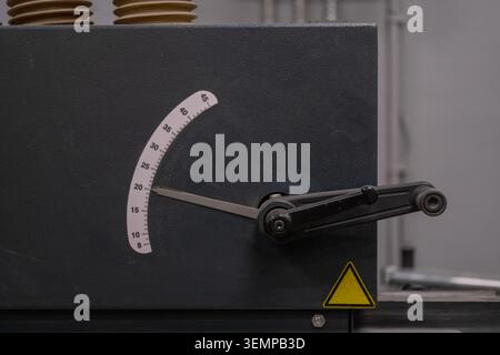 Mechanical adjustment control integrated into industrial production equipment in a modern manufacturing environment. The image represents precision pr Stock Photo