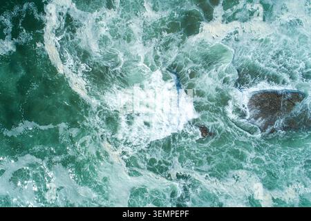 Drone perspective of swirling white foam on deep green sea The Concept of coastal environment Stock Photo