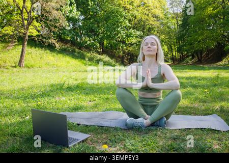 Beautiful blonde woman making video yoga practice and meditation Stock Photo