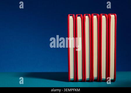 Six red hardcover notebooks for taking notes standing in a row Stock Photo