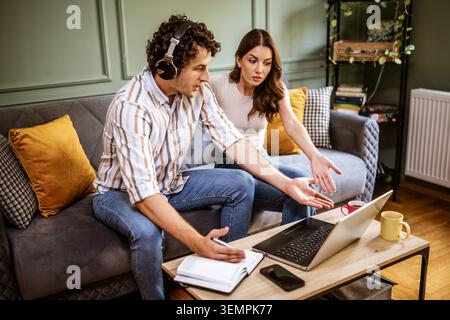 Woman is angry because her man is working too much. Freelancer working from home and arguing with his woman. Stock Photo