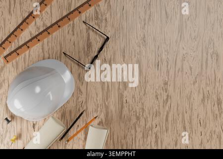 3D illustration of an engineer workspace. White hard hat, rulers, glasses, and pencils on a wooden background with copy space. Concept of construction Stock Photo