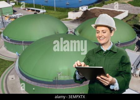 Engineer with digital tablet on a background of biogas plant Stock Photo