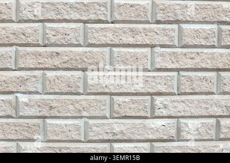 Weathered light gray stone wall texture with rectangular blocks and cracks Stock Photo