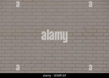 Weathered light gray stone wall texture with rectangular blocks and cracks Stock Photo