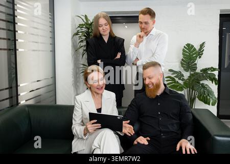 Business team discussing project strategy using digital tablet in office Stock Photo