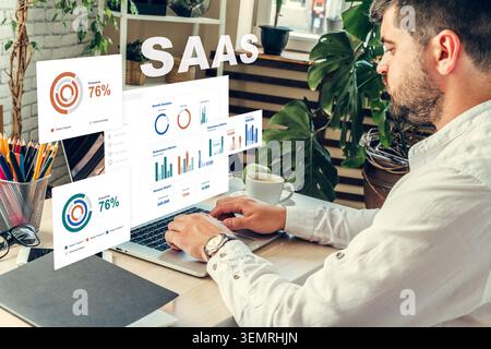 Working on SaaS metrics while analyzing data on a laptop in an office setting Stock Photo