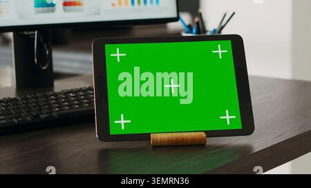 Green screen projection on interactive tablet with chroma key theme appears on company desk. Isolated mockup design displayed on advanced handheld gadget, blank copy space layout. Close up. Stock Photo