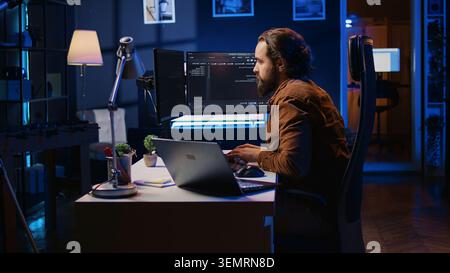 Developer pressed by deadline, drinking coffee and doing multitasking to finish developing PC code. Stock Photo