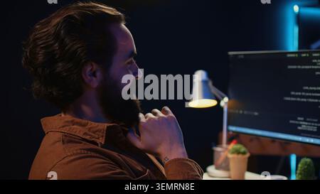 Happy self employed developer in home office doing coding on computer at desk. Joyful IT specialist doing contracted job from apartment, writing lines of code at workstation. close up. Stock Photo