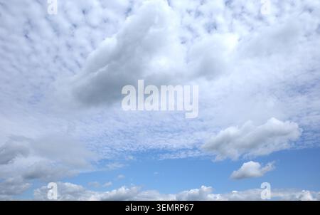 A sky filled clouds and in a higer region altocumulus clouds, characterized by white patches and rounded clumps. Stock Photo