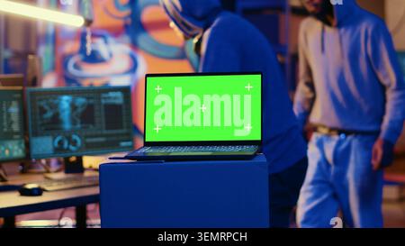 Isolated screen laptop used by cybercriminals in abandoned warehouse to write lines of code, developing malware that get past security systems. Mockup device used by rogue programmers in secret. Stock Photo
