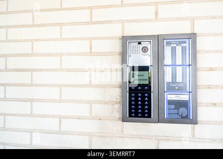 Modern electronic intercom and access keypad on a white brick wall Stock Photo