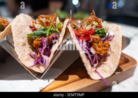 Close-up of vibrant street-style tacos with crispy fried toppings, shredded purple cabbage, fresh Stock Photo