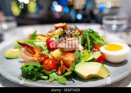 Fresh garden salad with grilled chicken, avocado, cherry tomatoes, corn, strawberries, and a Stock Photo