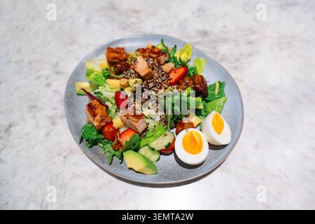 Fresh healthy salad with grilled chicken, quinoa, avocado, strawberries, and soft-boiled eggs on a Stock Photo