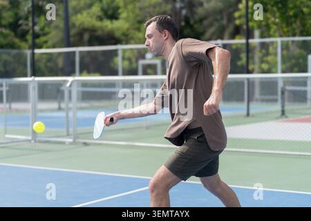 Active Diverse People Playing Pickleball on Outdoor Court Stock Photo