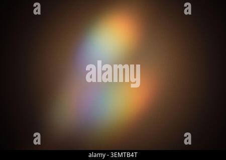Soft colorful light spectrum refracting across dark background, creating bokeh effects Stock Photo