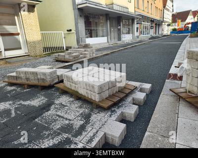 Germany, Rietberg - June 5th 2026: Road construction work in a historic old town. Freshly laid paving and stone slabs on pallets characterize the scen Stock Photo