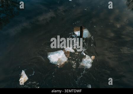 Ice breaking against a wooden piling in the dark River. Stock Photo