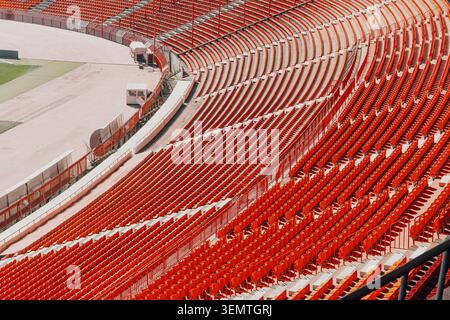Empty stadium seats creating a patterned background. Bright orange bleachers in an athletic arena awaiting spectators Stock Photo