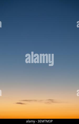 Clear and empty blue and yellow orange gradient sky for background, vertical image Stock Photo