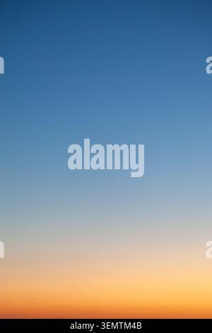 Clear and empty blue and yellow orange gradient sky for background, vertical image Stock Photo