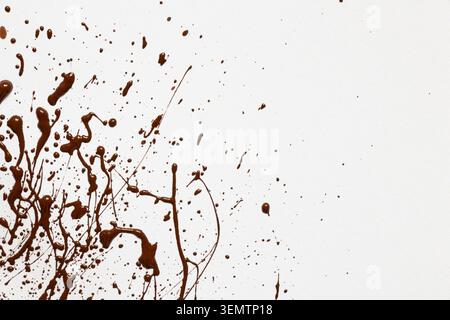 Brown acrylic paint splashes on a white background with a contrasting texture and splatter effect as a background Stock Photo