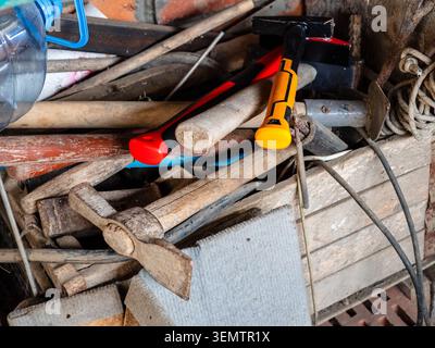 old and new construction and garden tools close-up in wooden box in village barn Stock Photo