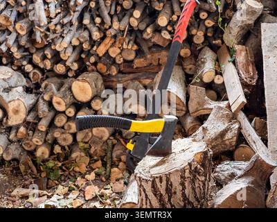 axe into stump and cleaver neat sawn firewood in village barn Stock Photo