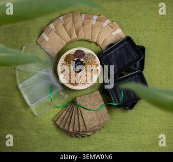 Microgreens growing kit with seeds scattered on a wooden stand. Complete home microgreens growing kit is displayed as flat lay on textured green fabri Stock Photo