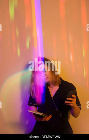 Communication with the client using two phones at the same time. Young woman in uniform ?ommunication with the client by phone. Stock Photo