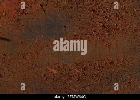 Detailed background of dark rusty iron plate texture. Full frame of heavily corroded metal surface with rough industrial texture and brown tones. Stock Photo