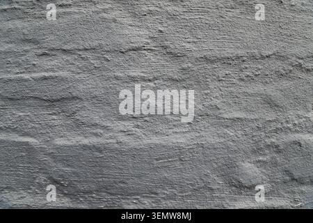 Roughly applied dark gray stucco layer on an outdoor masonry wall structures providing an abstract textured background option for digital artwork Stock Photo