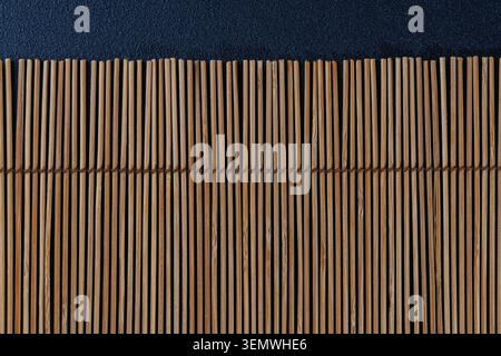 Vertical Bamboo Reed Mat on Dark Blue Minimal Background Stock Photo