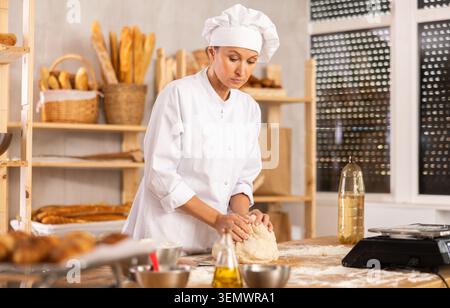Professional baker kneading dough Stock Photo