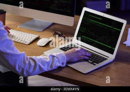 Female programmer working with computer and laptop in office at night Stock Photo