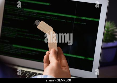 Female hand with USB flash drive and laptop in office, closeup Stock Photo