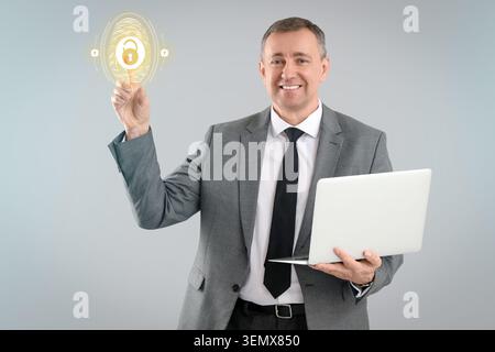 Businessman with laptop activating digital fingerprint security, cybersecurity and data protection Stock Photo