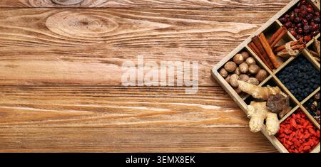 Assorted dried spices and herbs in wooden box on rustic table for culinary and medicinal use Stock Photo